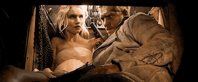 a man is holding a gun next to a woman who is laying on the floor