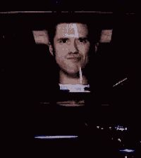 a man is screaming in a dark room while holding a remote control .
