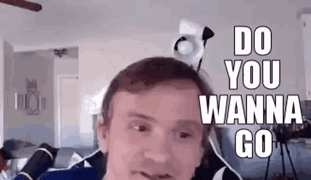 a man is sitting in a living room with a microphone on his head .