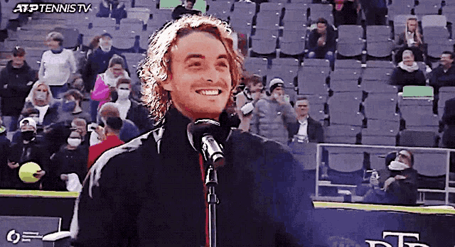 a man stands in front of a microphone with atp tennis tv written on the bottom left