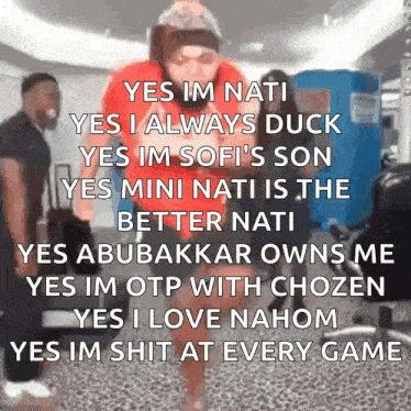 a man in a red shirt is standing in front of a blue box that says ' yes im nati ' on it