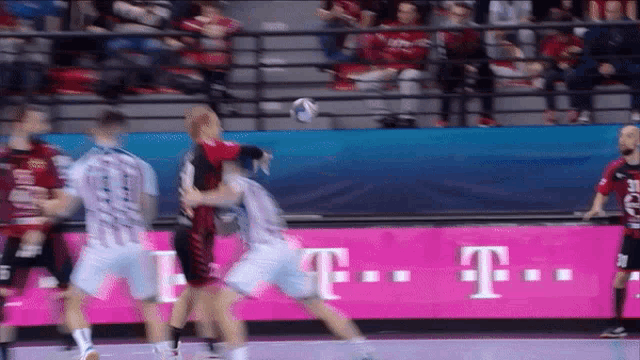 a t-mobile advertisement can be seen in the background of a basketball game