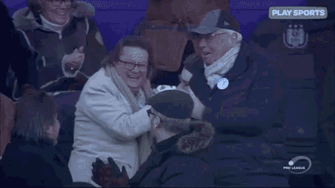 a group of people are sitting in a stadium with a sign that says play sports .