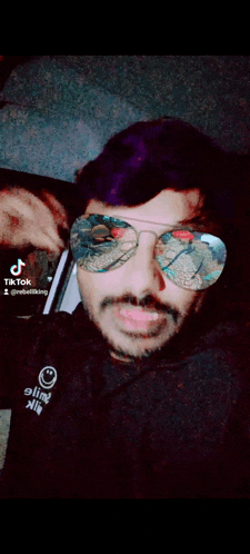 a man wearing sunglasses and a shirt that says tik tok