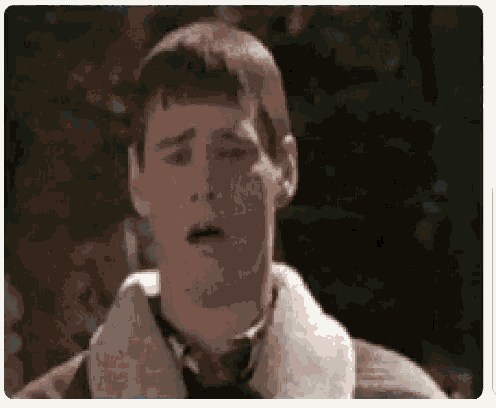 a close up of a man making a funny face while wearing a jacket .