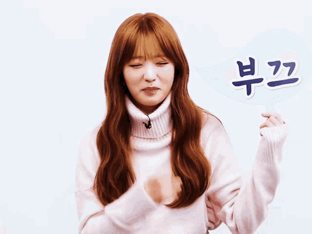 a woman in a pink sweater is holding a sign that says ' bubble ' on it