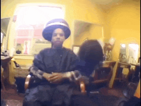 a man wearing a hat is sitting in a chair in a room .