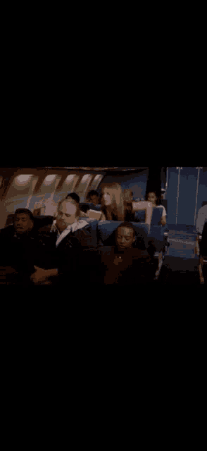 a group of people are sitting on a plane and one of them is making a face