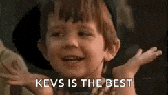 a little boy is smiling and saying `` kevs is the best '' with his hands outstretched .