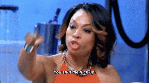 a woman in a red dress is yelling at someone and saying `` you shut the fuck up ! ''
