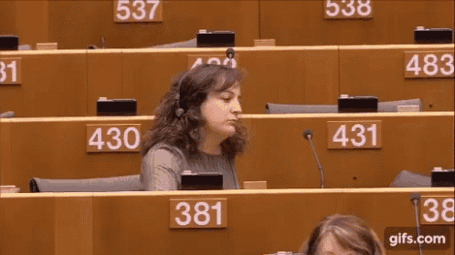 a woman wearing headphones is sitting at a desk with the number 431