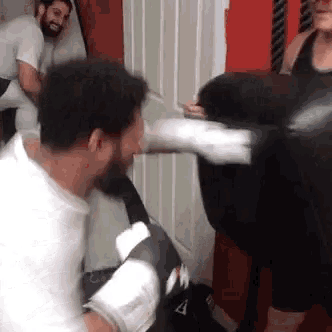 a man is hitting a punching bag with his fist .