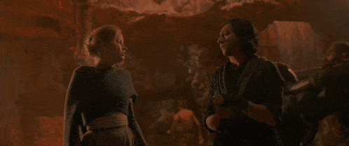 a man and a woman are standing next to each other in a dark room in a cave .