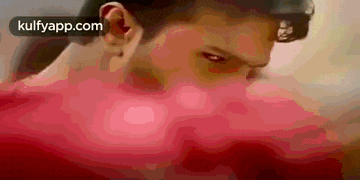 a close up of a man 's face with a red background and a blurred background .