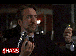 a man is sitting at a table with his hands folded in front of a sign that says ' hans ' on it
