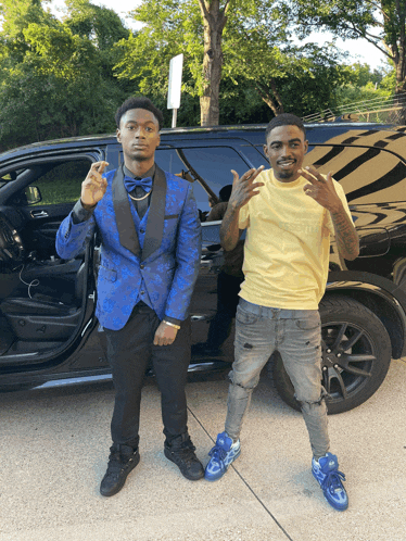 a man in a blue suit stands next to another man