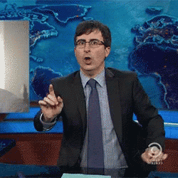 a man in a suit and tie is talking in front of a world map