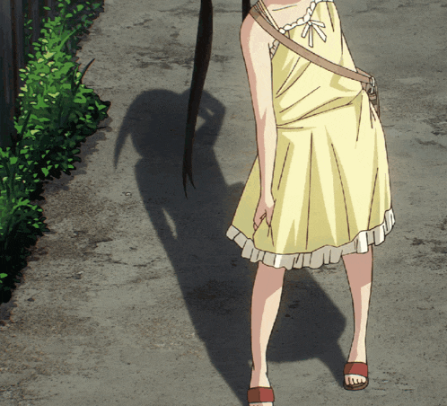 a girl in a yellow dress and red sandals is standing on a sidewalk