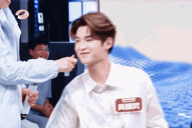 a man in a white shirt has a name tag on his chest that says ' huang ' on it