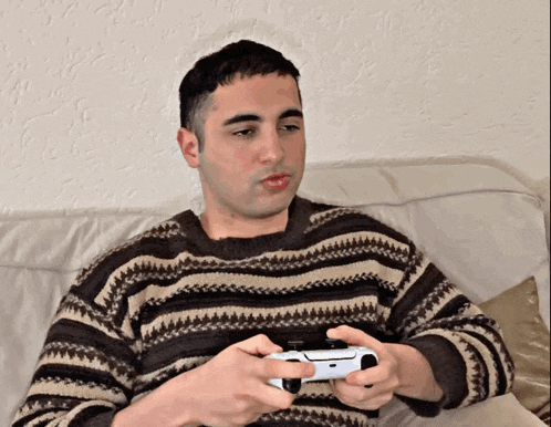 a man in a striped sweater is holding a video game controller