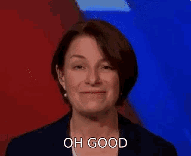 a woman in a suit is making a funny face and saying `` oh good '' .