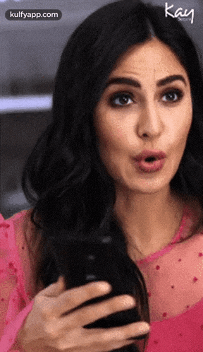 katrina kaif is wearing a pink dress and holding a phone