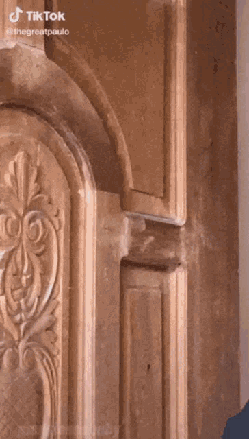 a close up of a wooden door with a carved design