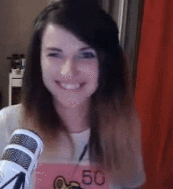 a woman wearing a shirt with the number 50 on it is smiling in front of a microphone