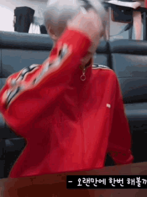 a man in a red jacket is covering his face