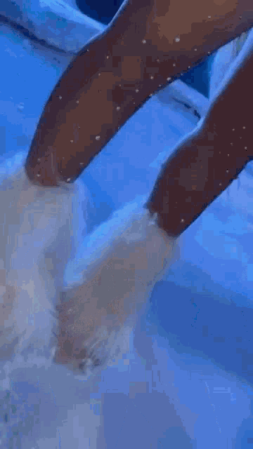 a close up of a person 's feet in a pool of water .