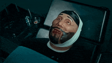 a man with a bandage on his face is laying on a bed