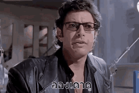 a man wearing glasses and a leather jacket is looking at the camera .