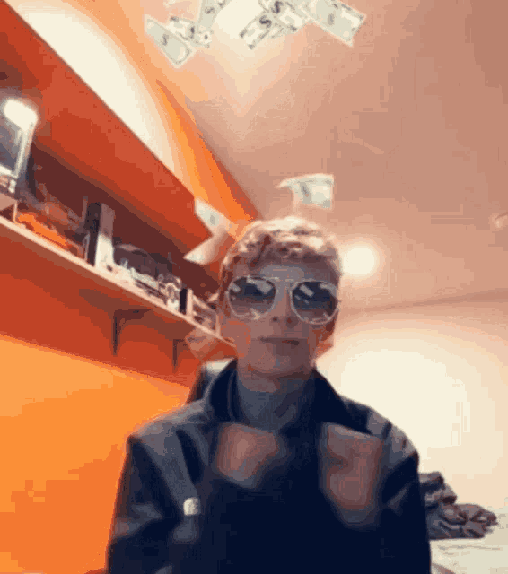 a man wearing sunglasses is surrounded by money