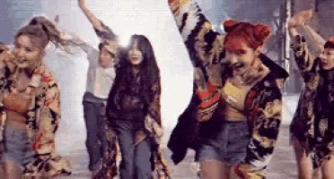 a group of young women are dancing together in a dark room .
