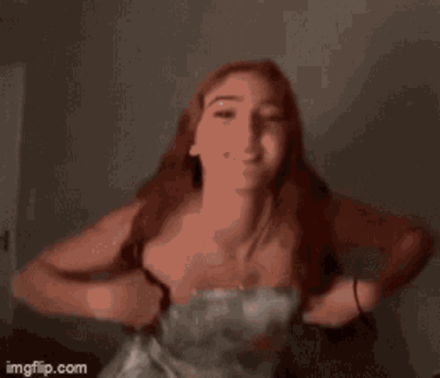 a woman in a strapless dress is dancing in front of a wall with imgflip.com written below her