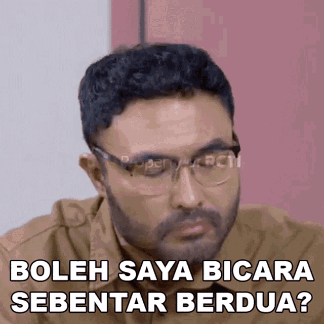 a man wearing glasses says " boleh saya bicara sebentar berdua "