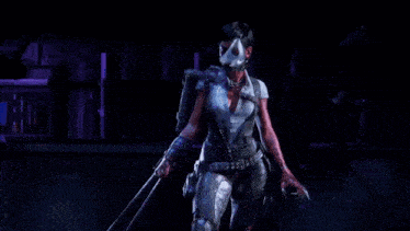 a woman with a mask on her face is dancing in a dark room