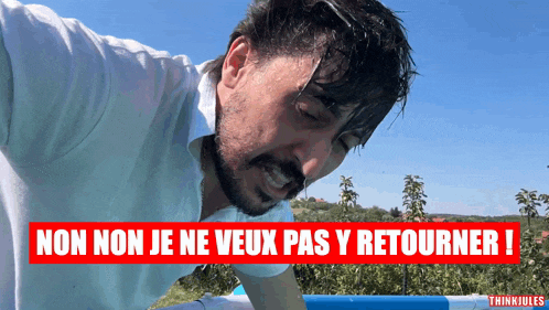 a man in a white shirt stands in front of a sign that says non non je ne veux pas y retourner