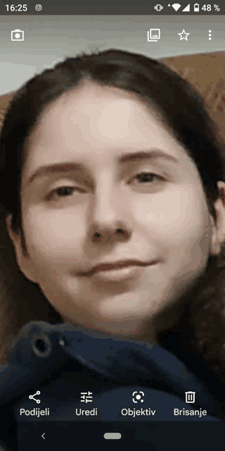 a woman 's face is displayed on a cell phone screen