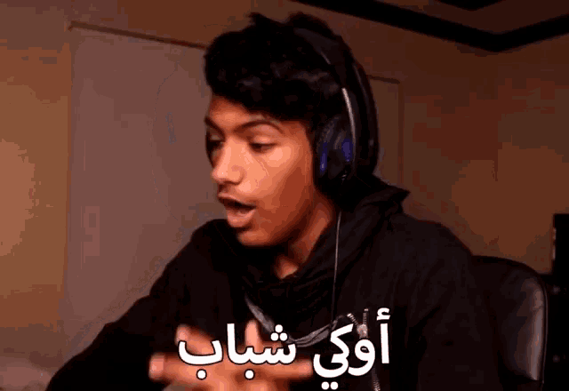 a young man wearing headphones with arabic writing on the bottom of his face
