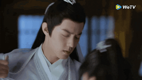 a man in a white kimono is standing next to a woman in a black dress .