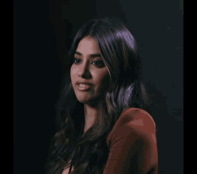 a woman with long dark hair is making a funny face