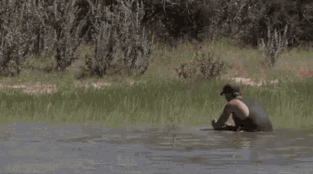 a man is standing in a body of water with smoke coming out of it .