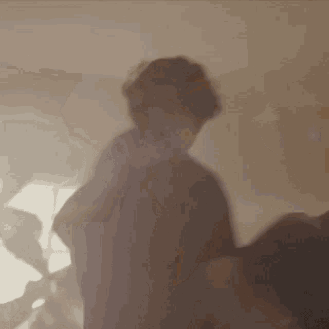 a blurry picture of a person standing in a room with smoke coming out of the window .
