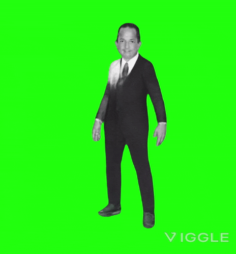 a man in a suit dancing on a green screen