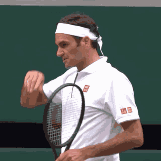a man wearing a headband holds a tennis racket