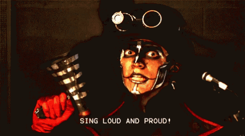 a man with face paint and goggles is singing loud and proud