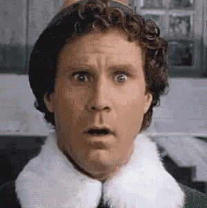 a close up of a man 's face with his mouth open and a surprised look on his face .