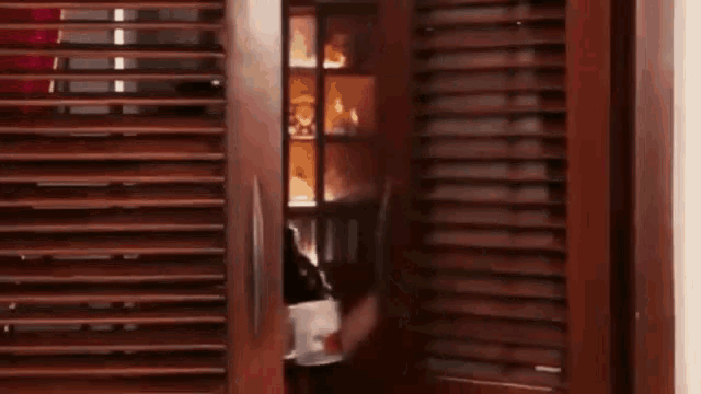 a woman is standing in front of a door holding a cup of coffee