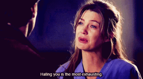 a woman in a blue scrub is crying while a man says " hating you is the most exhausting "
